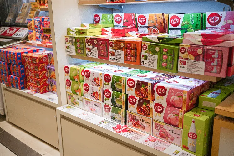 Stack of Kit Kat bars in a variety of exclusive flavors found only in Japan, showcasing unique regional and seasonal flavors from matcha to wasabi and more