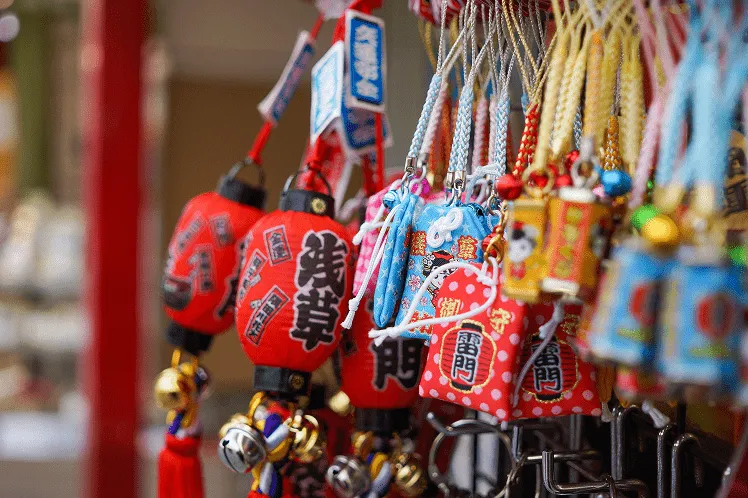 Traditional Japanese souvenirs displayed in shops include colorful mobile phone charms, known locally as sutorappu, featuring designs inspired by local culture