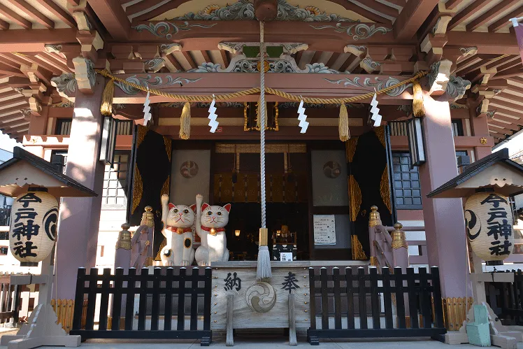 Imado Shrine with two large beckoning cat statues sitting outside, welcoming visitors with their iconic lucky paw poses