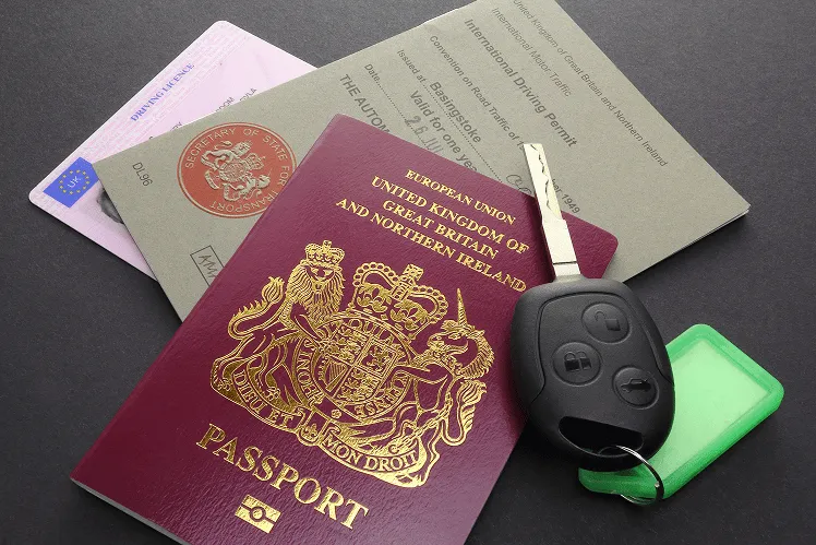 Collection of documents required for renting a car, including a passport, a driver’s license, and an international driving permit