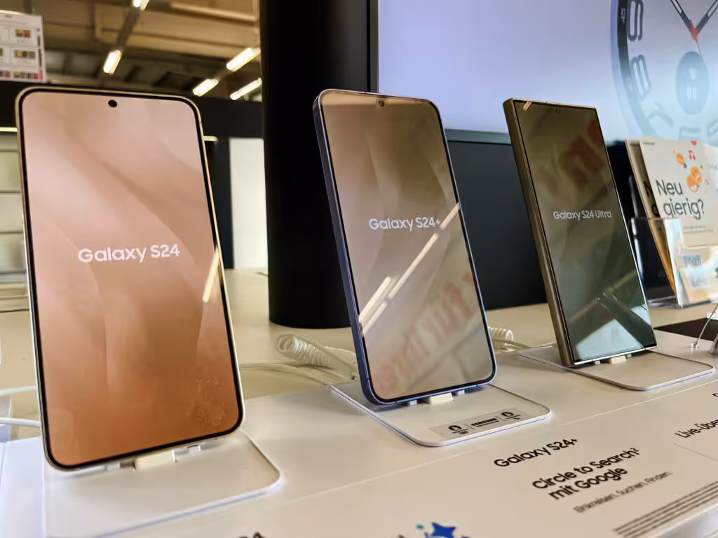 The image shows a retail display of three Samsung smartphones: the Galaxy S24, Galaxy S24+, and Galaxy S24 Ultra