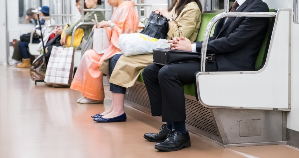 People are sitting quietly on a Japanese metro train, behaving politely and not disturbing anyone around them