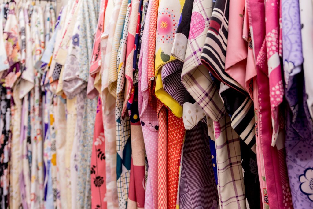 A vibrant kimono rental store displays an enticing array of traditional Japanese garments hanging neatly on racks, ready for customers to rent and experience cultural elegance