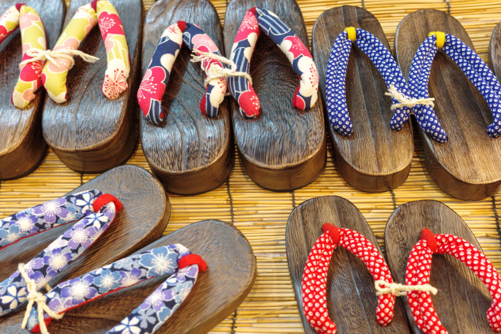 Traditional Japanese wooden slippers, geta or zori with colourful  fabric or straw (hanao) in vibrant blue, yellow, red, and purple